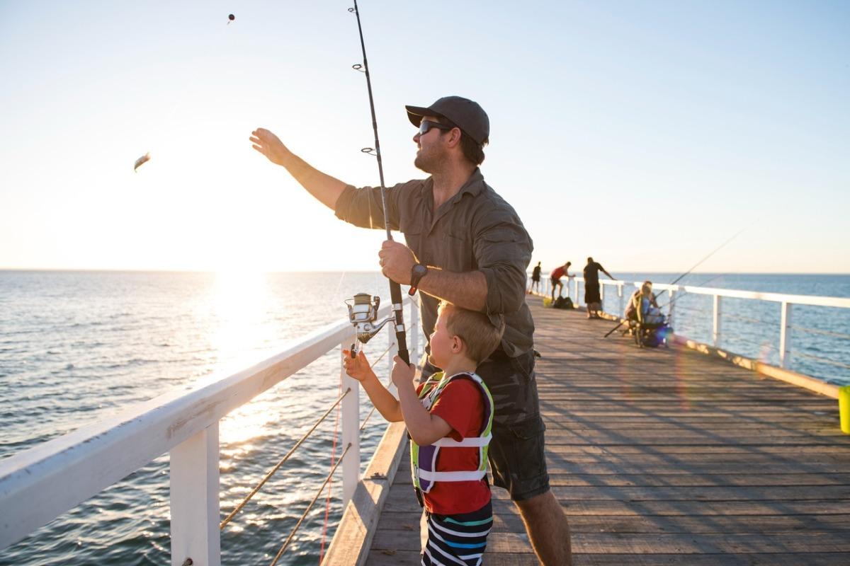 Father and Son on a pier fishing and enjoying time together on Father's Day