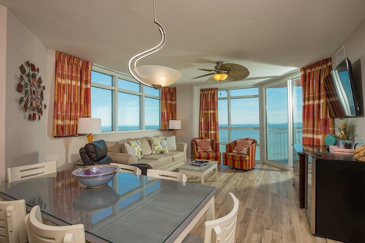 spacious living room and dining area with a stunning view of the beach